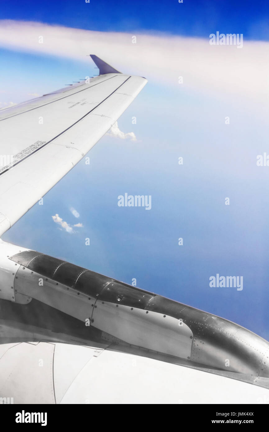 Flügel des Flugzeugs in Wolken bei sonnigem Wetter Stockfoto