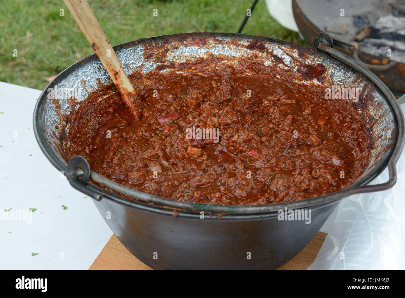 Eine große Schüssel mit Chili con carne in einem gusseisernen Topf über offenem Feuer Gower Chili Festival Glamorgan Wales gekocht Stockfoto