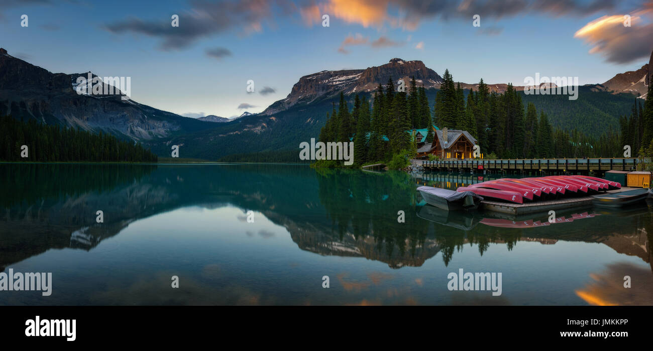 Kanus am wunderschönen Emerald See Lake Lodge und Restaurant im Hintergrund bei Sonnenuntergang, Yoho Nationalpark, Britisch-Kolumbien, Kanada. Lange exposu Stockfoto