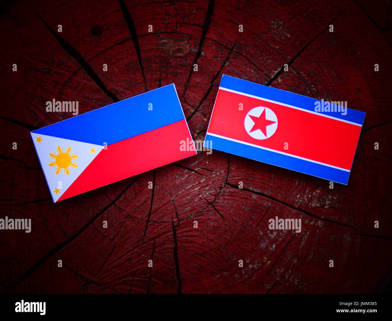 Philippinen-Flagge mit nordkoreanischer Flagge auf einem Baumstumpf, isoliert Stockfoto
