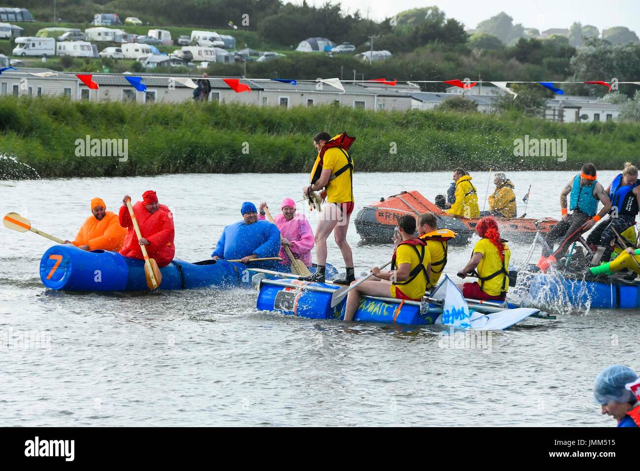 West Bay, Dorset, UK.  27. Juli 2017.  Jährliche RNLI Floß Rennen auf dem Fluss Brit im Badeort von West Bay in Dorset.  Teilnehmer unter dem Motto Kostüm tragen und gründlich nass, als sie Wasserschlachten auf der Startlinie.  Bildnachweis: Graham Hunt/Alamy Live-Nachrichten Stockfoto
