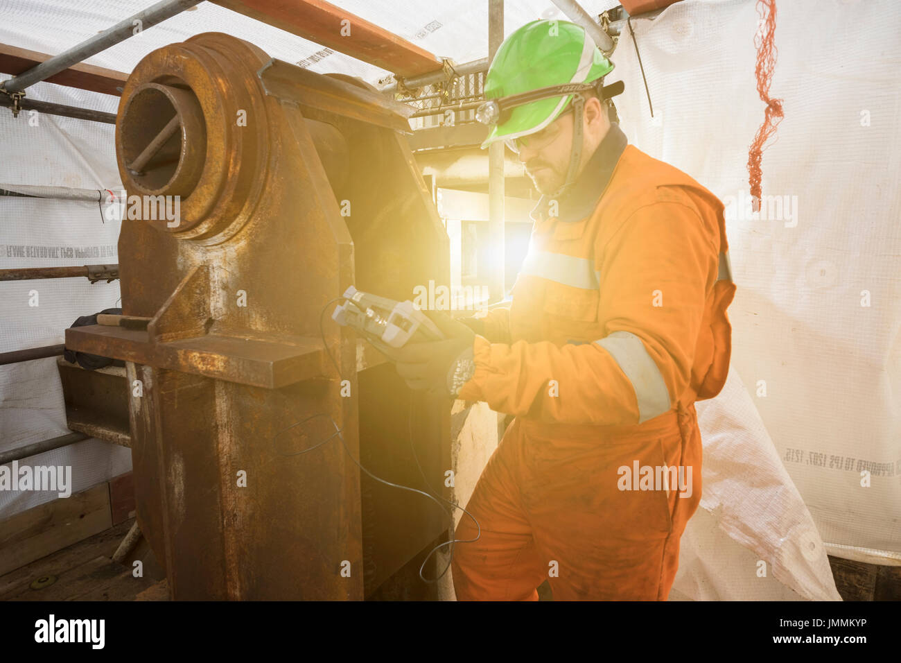 NDT Inspector, schweißen Sie dicke prüfen, auf der Nordsee Öl- und Gasindustrie rig. Tragen orange Overalls/Overalls. Credit: LEE RAMSDEN/ALAMY Stockfoto
