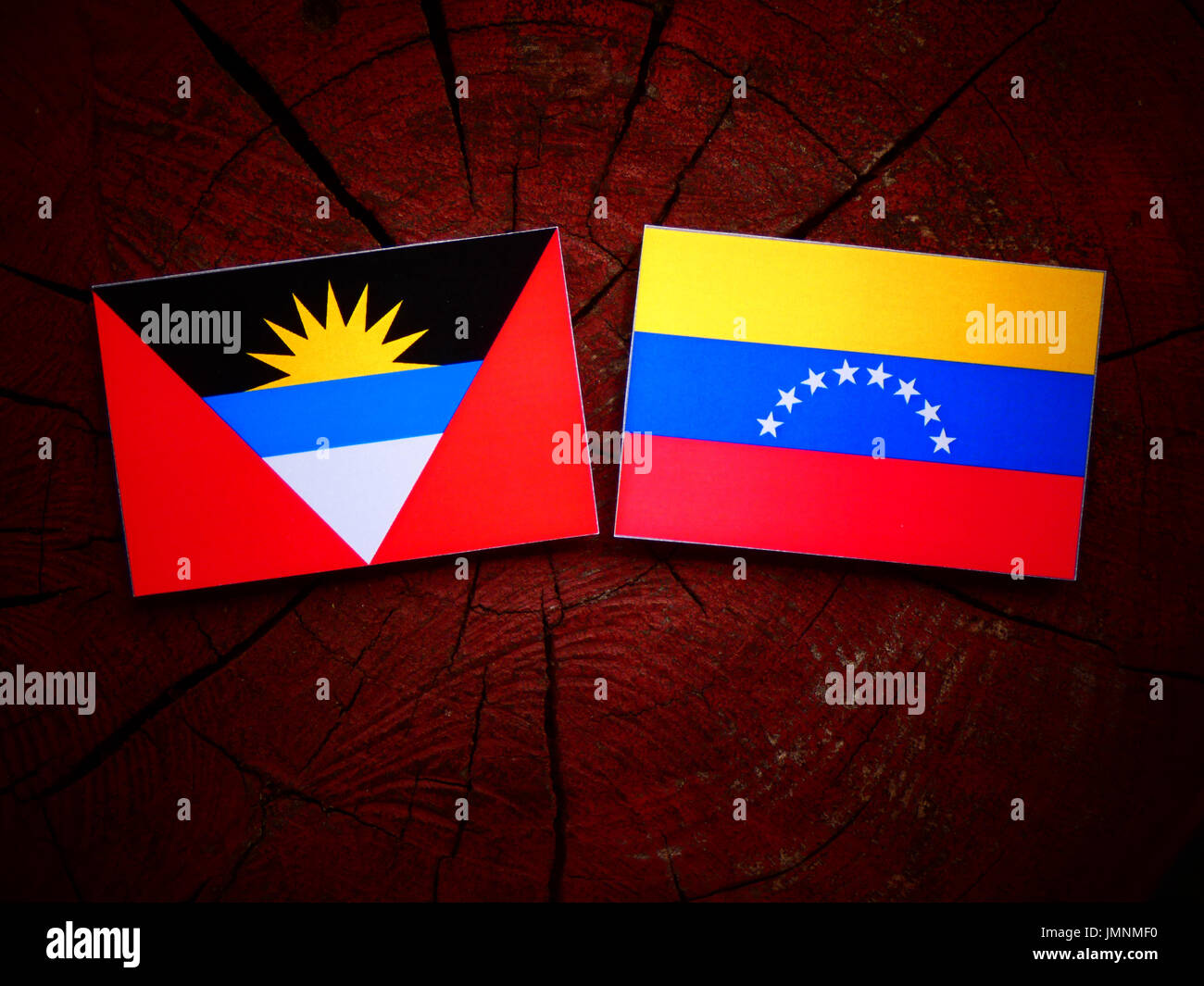 Antigua und Barbuda Flagge mit venezolanischen Flagge auf einem Baumstumpf, isoliert Stockfoto