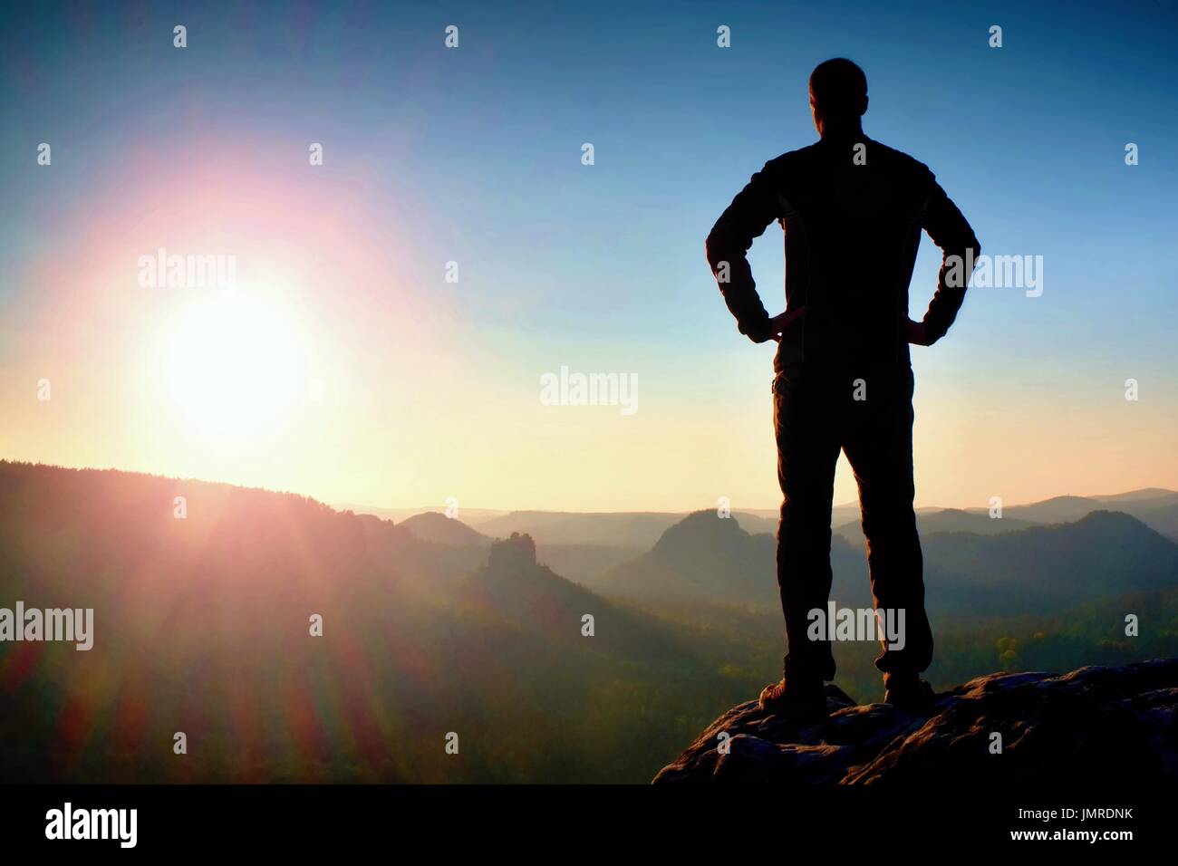 Silhouette der junge selbstbewusste und starke Mann stehend mit Händen auf den Hüften, späten Tag Sonne mit Textfreiraum Stockfoto