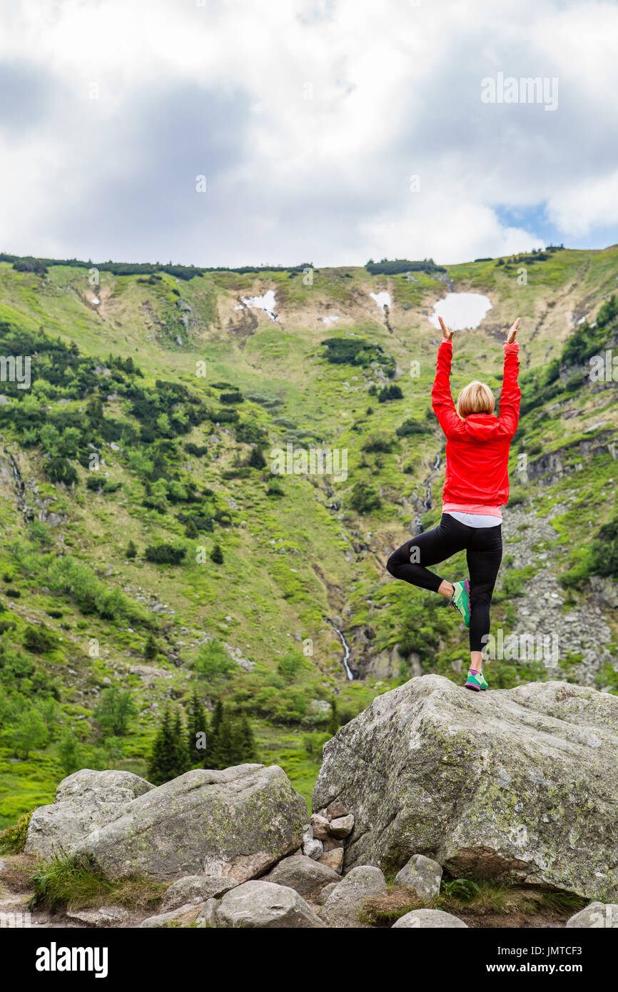 Frau in Yoga-Pose vor der Bergsee zu meditieren. Weibliche Wanderer in inspirierende Berge Landschaft entspannen. Gesunde Lebensweise zu übertreffen Stockfoto