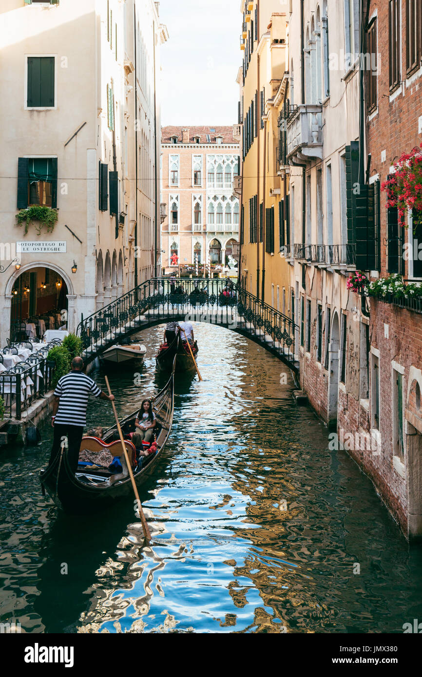 Gondeln auf einem schmalen Kanal führt zum Canal Grande in Venedig. Gondelfahrten und Touren sind sehr beliebt bei Touristen sind iconic Besonderheiten der Stadt Stockfoto