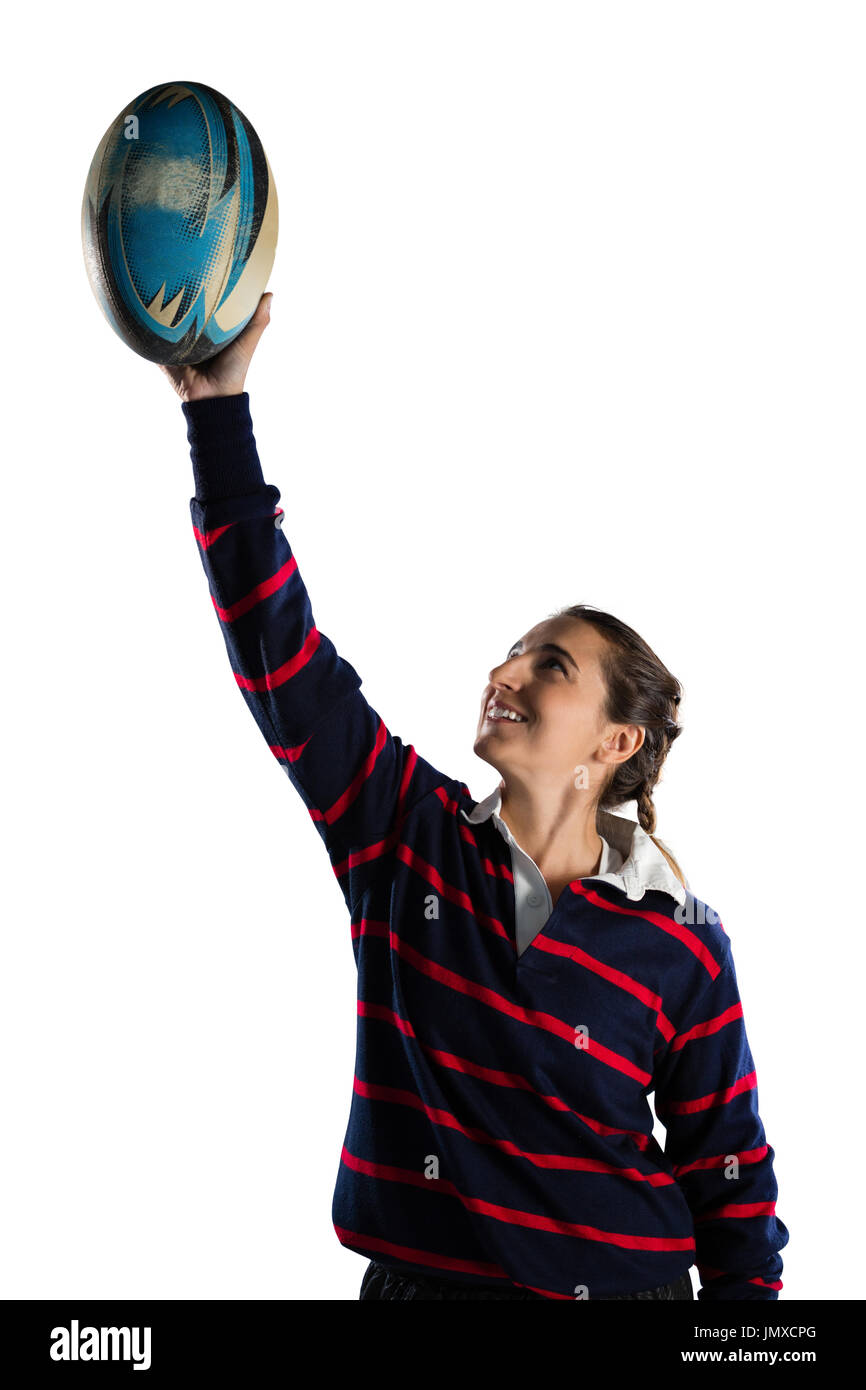 Glücklich Sportlerin mit Armen angehoben halten Rugby Ball stehend vor weißem Hintergrund Stockfoto