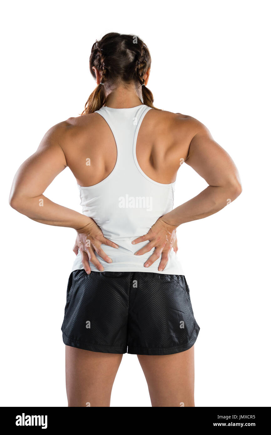 Rückansicht der Sportlerin leiden unter Schmerzen im Rücken beim stehen auf weißen Hintergrund Stockfoto