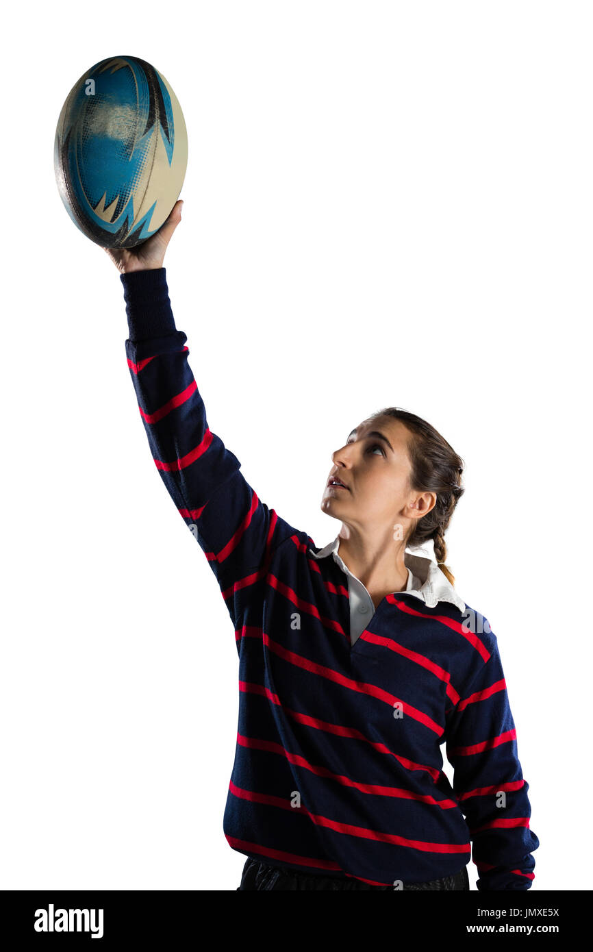 Sportlerin mit Armen angehoben halten Rugby Ball stehend vor weißem Hintergrund Stockfoto