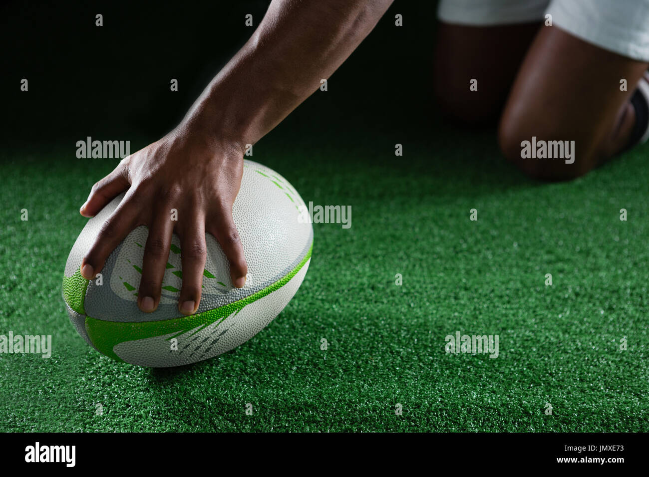 Nahaufnahme des Sportlers mit Rugby-Ball auf Feld Stockfoto