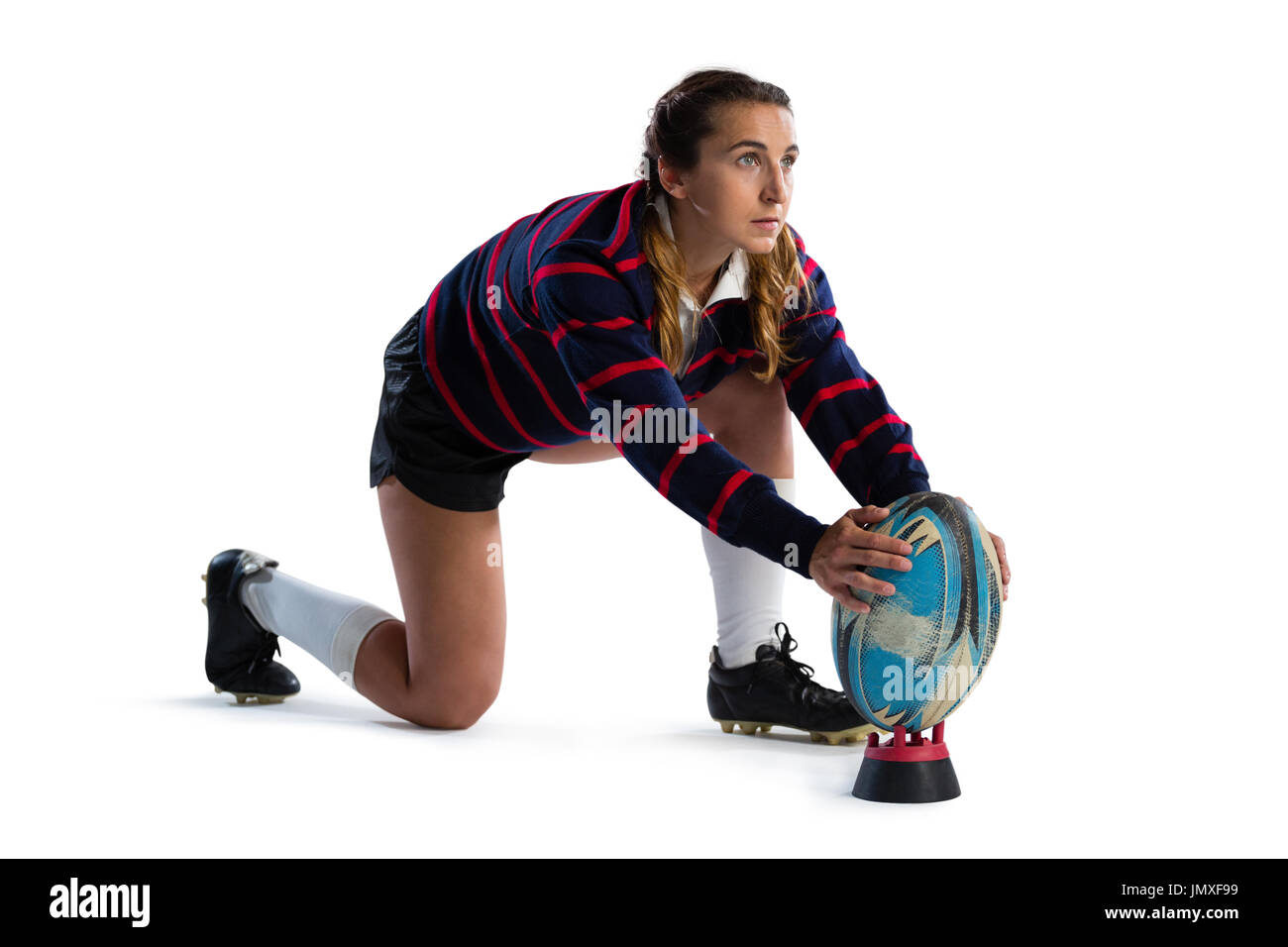 Gesamte Länge der jungen Sportlerin Rugby-Ball am Abschlag zu halten, kniend vor weißem Hintergrund Stockfoto