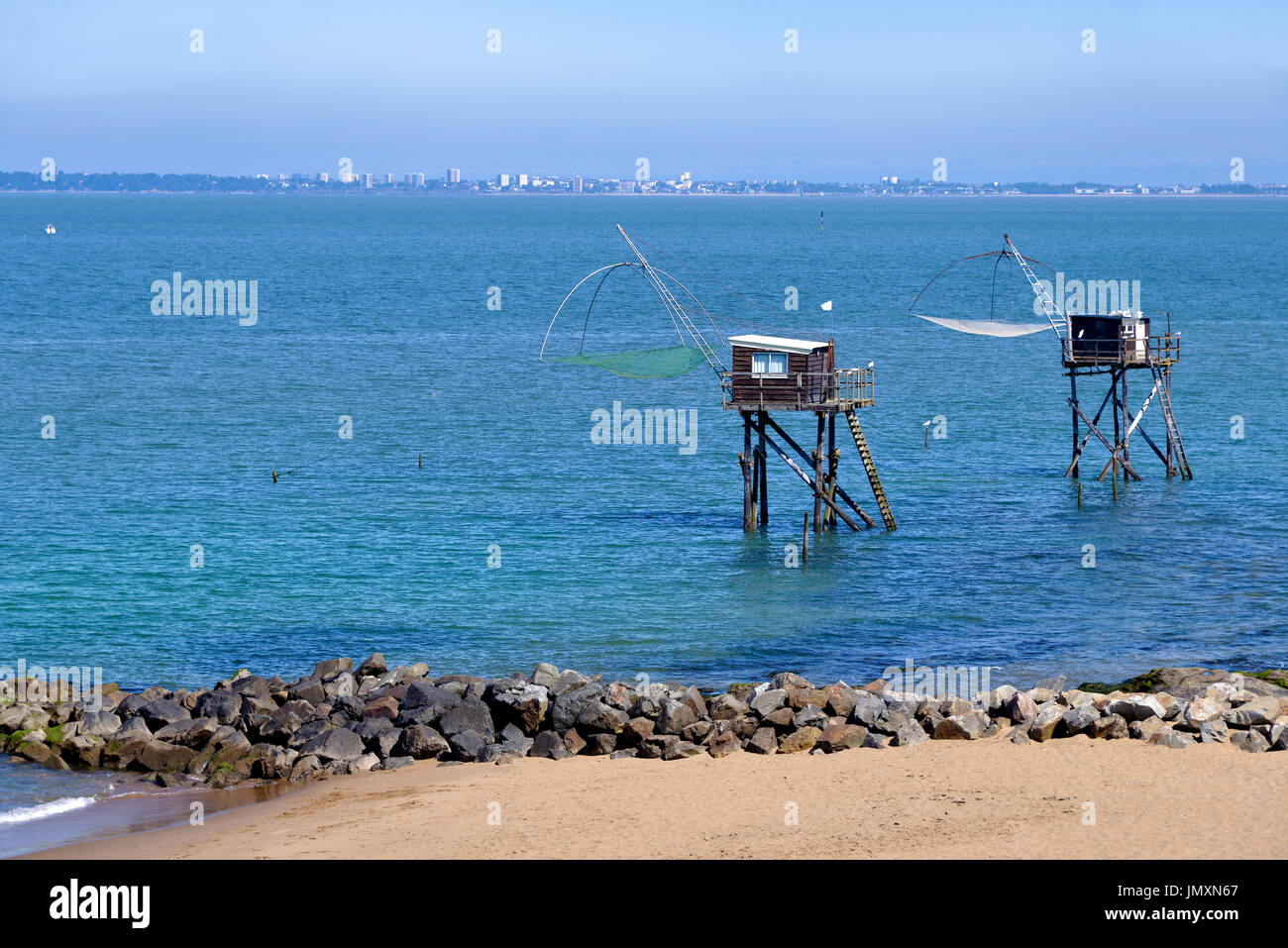 Angeln Carrelets und die Stadt von Saint-Nazaire im Hintergrund, Saint-Michel-Chef-Chef im Departement Loire-Atlantique in Westfrankreich. Stockfoto