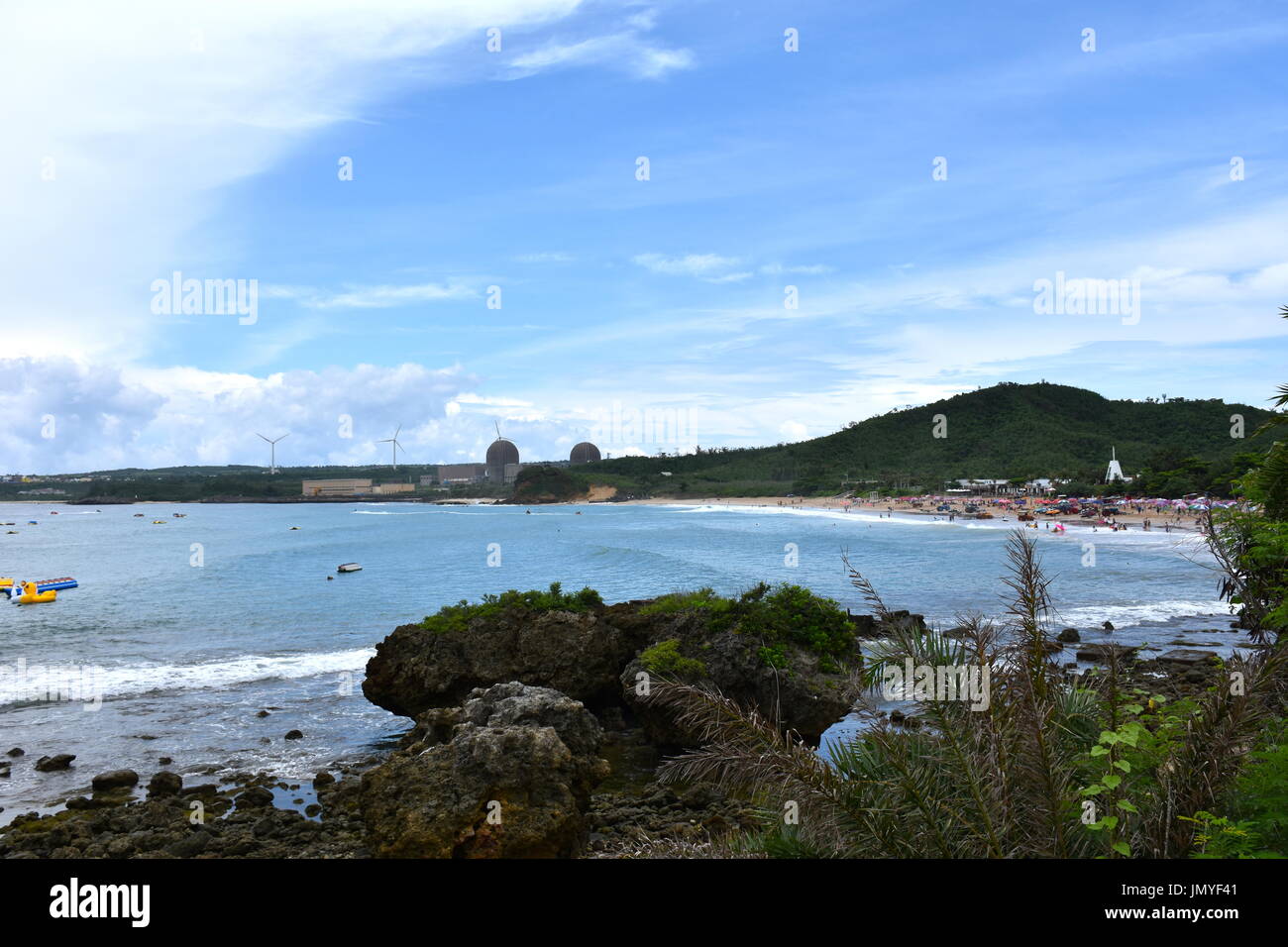 Dies ist ein Kernkraftwerk im südlichen Taiwan mit drei Wind angetrieben Windmühlen hinter ihnen das Publikum glücklich zu machen. Stockfoto