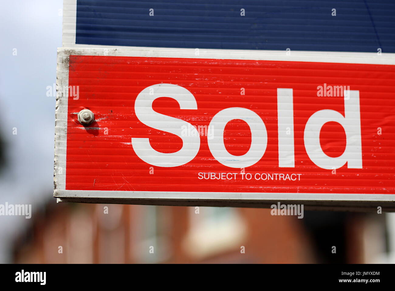 Immobilienmakler verkauft Zeichen mit Häusern im Hintergrund Stockfoto