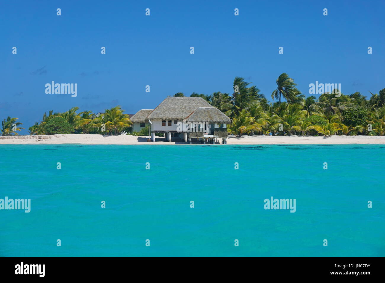 Küste mit einem tropischen Strandhaus und türkisfarbenen Wasser der inneren Lagune, Atoll Tikehau, Tuamotus Archipel, Französisch-Polynesien, Pazifischer Ozean Stockfoto