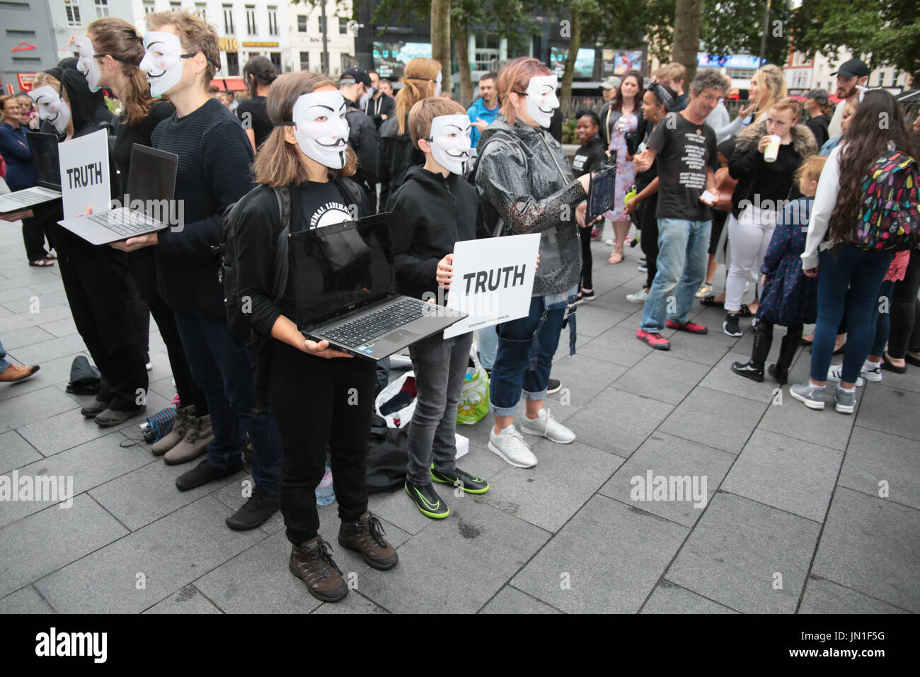 London UK 29. Juli 2017 Menschen tragen Guy Fawkes-Masken, Veganismus und Tierschutz mit Tabletten in ihren Händen mit schrecklichen Aufnahmen von Tierlandwirtschaft Praxis zu fördern. Grafischen Aufnahmen von Tieren leiden zwar schlachtet die gesichtslosen Menschen halten, dass die Tabletten bilden ein Quadrat oder ein Würfel, mit dem Wort der Wahrheit, kein Wort zu sagen, keinen Ton äußern, alles gesagt mit images.@Paul Quezada-Neiman/Alamy Live News Stockfoto