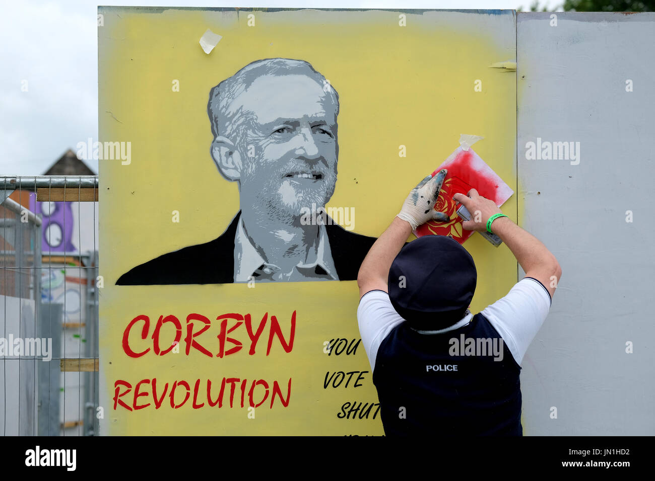 Bristol, UK. 29. Juli 2017. Eine Graffiti-Künstler, verkleidet als Polizist arbeitet auf ein Bild von Jeremy Corbyn. Bestandteil der Bristol Upfest 2017, Europas größte, frei, Straße Kunst & Graffiti-Festival zieht mehr als 300 Künstler Malerei 35 Orten in Bristol vom 29.-31. Juli 2017 Credit: Stephen Hyde/Alamy Live News Stockfoto