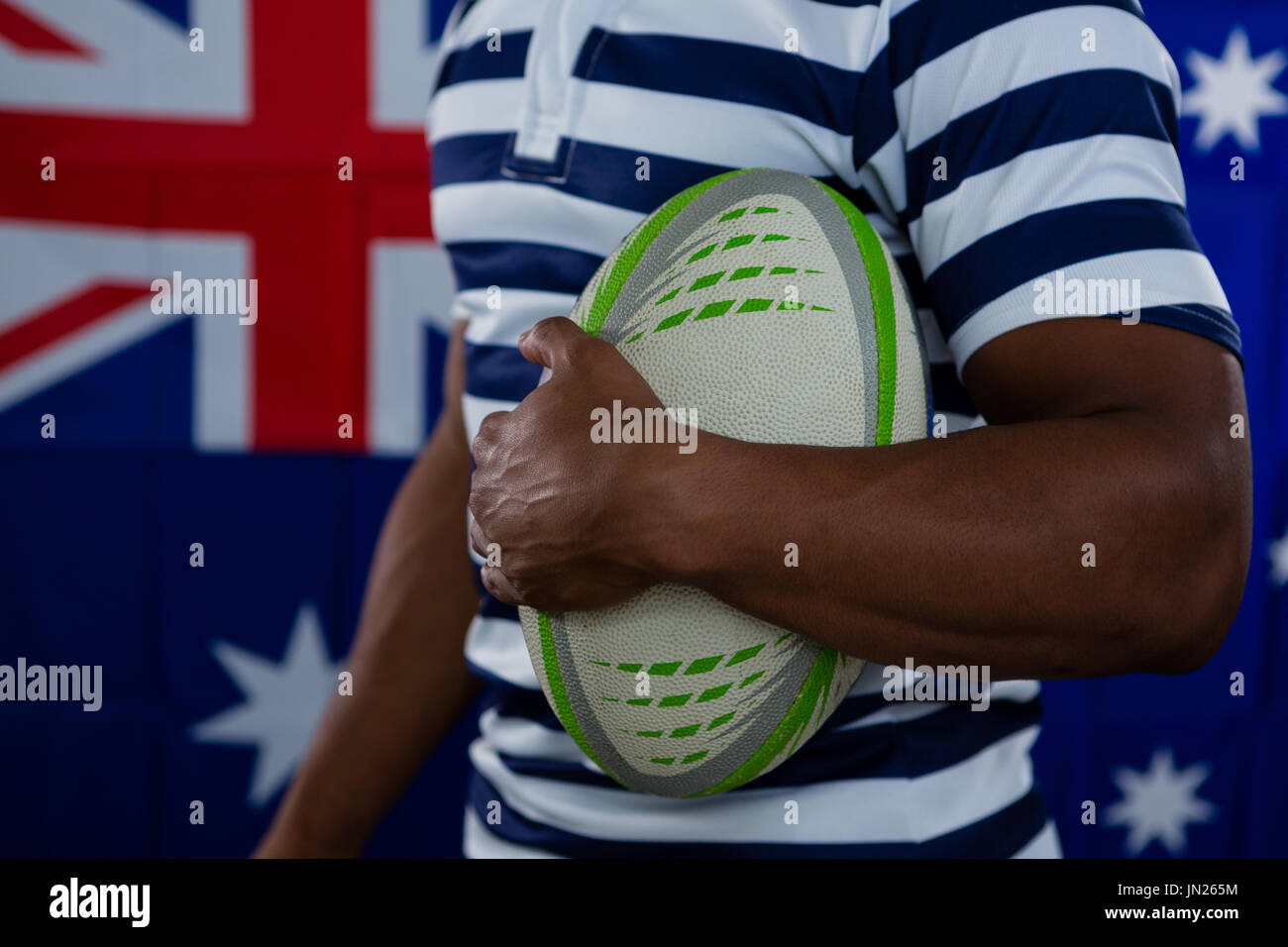 Mittleren Bereich der männlichen Athleten mit Rugby-Ball gegen australische Flagge Stockfoto
