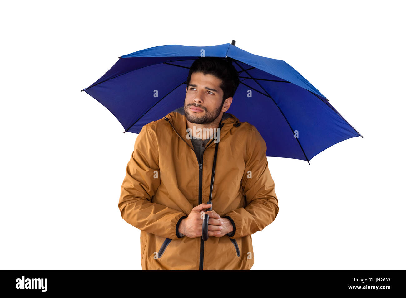 Junger Mann mit Regenschirm steht in einer regnerischen Nacht vor
