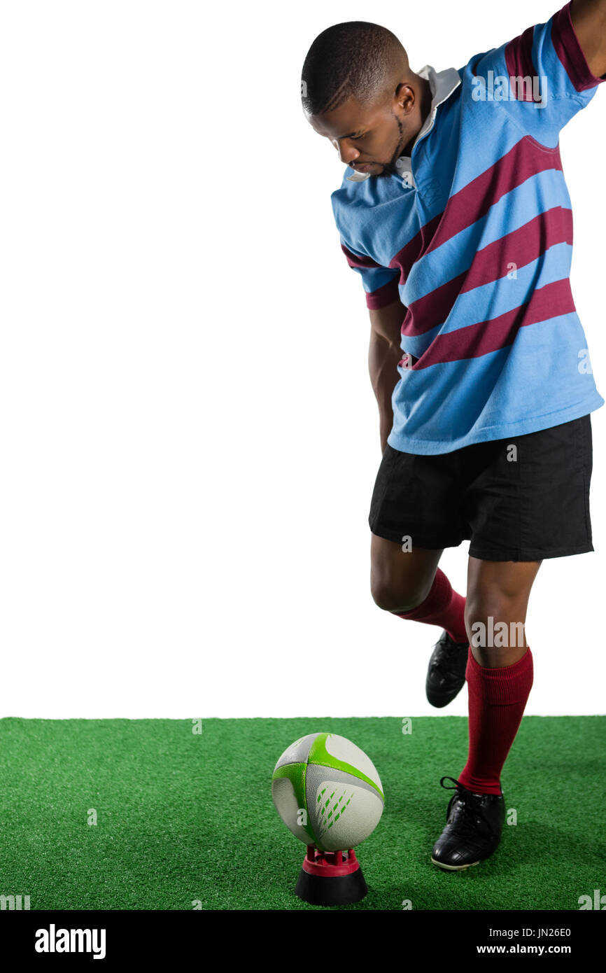 Volle Länge des männlichen Athleten treten Rugby-Ball vor weißem Hintergrund Stockfoto