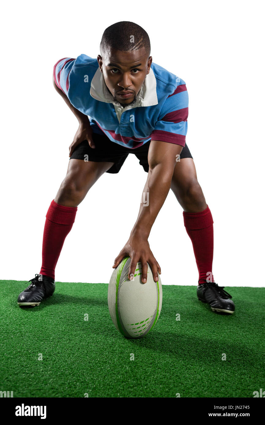 Gesamte Länge der männlichen Spieler mit Rugby-Ball Feld vor weißem Hintergrund Stockfoto