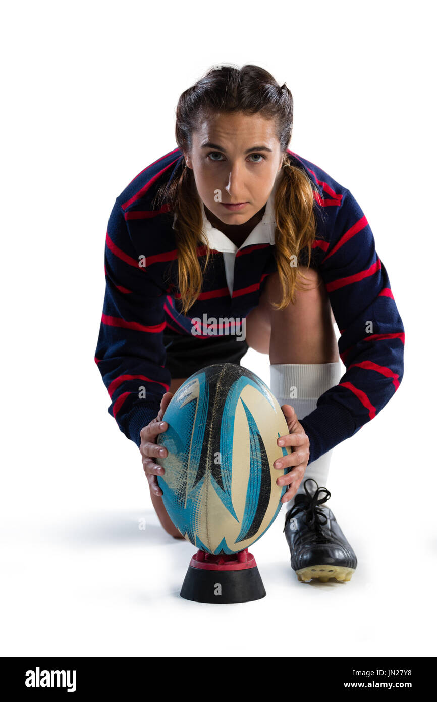 Porträt der Sportlerin Post Rugby-Ball behalten, kniend vor weißem Hintergrund Stockfoto