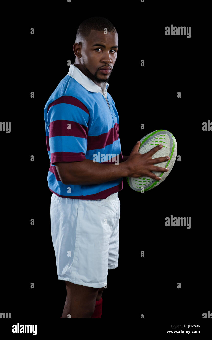 Seitenansicht der männlichen Spieler, Rugby-Ball stehend auf schwarzem Hintergrund Stockfoto