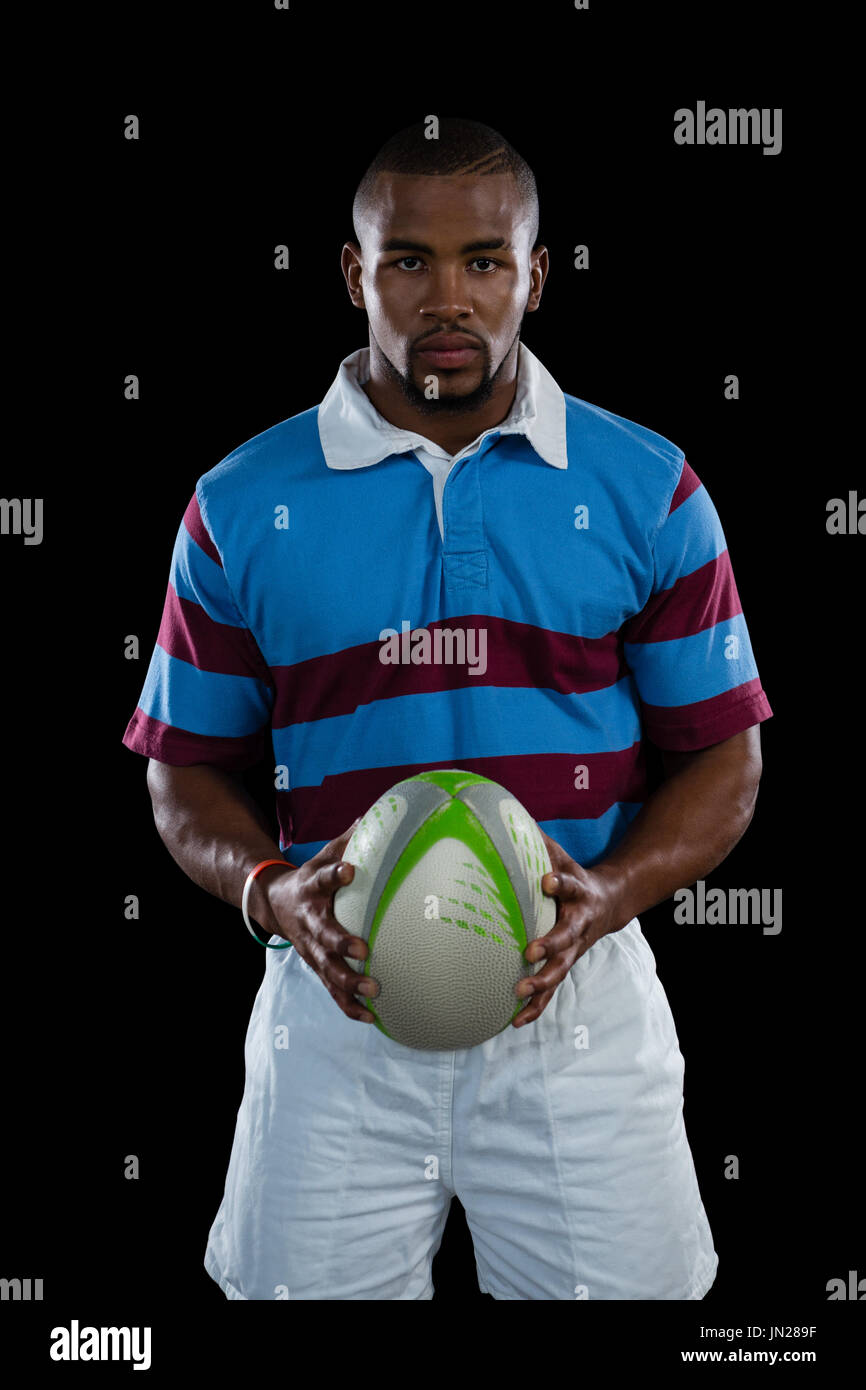 Porträt der männlichen Spieler, Rugby-Ball stehend auf schwarzem Hintergrund Stockfoto