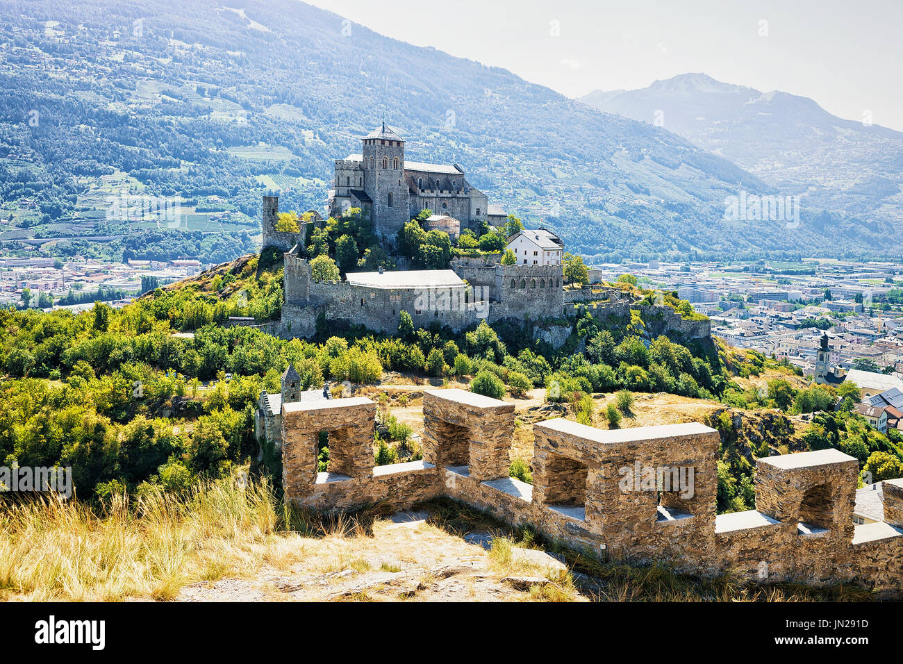 Valere Basilika und Tourbillon Burg auf dem Hügel in Sion, Hauptstadt des Kantons Wallis in der Schweiz. Berner Alpen im Hintergrund Stockfoto