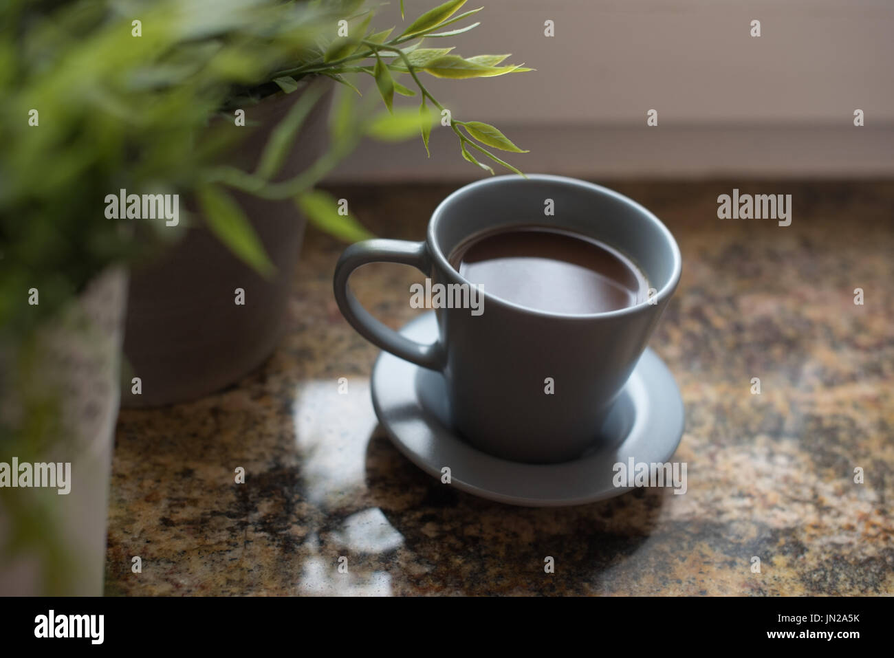 Nahaufnahme von Kaffeetasse am Tisch zu Hause Stockfoto