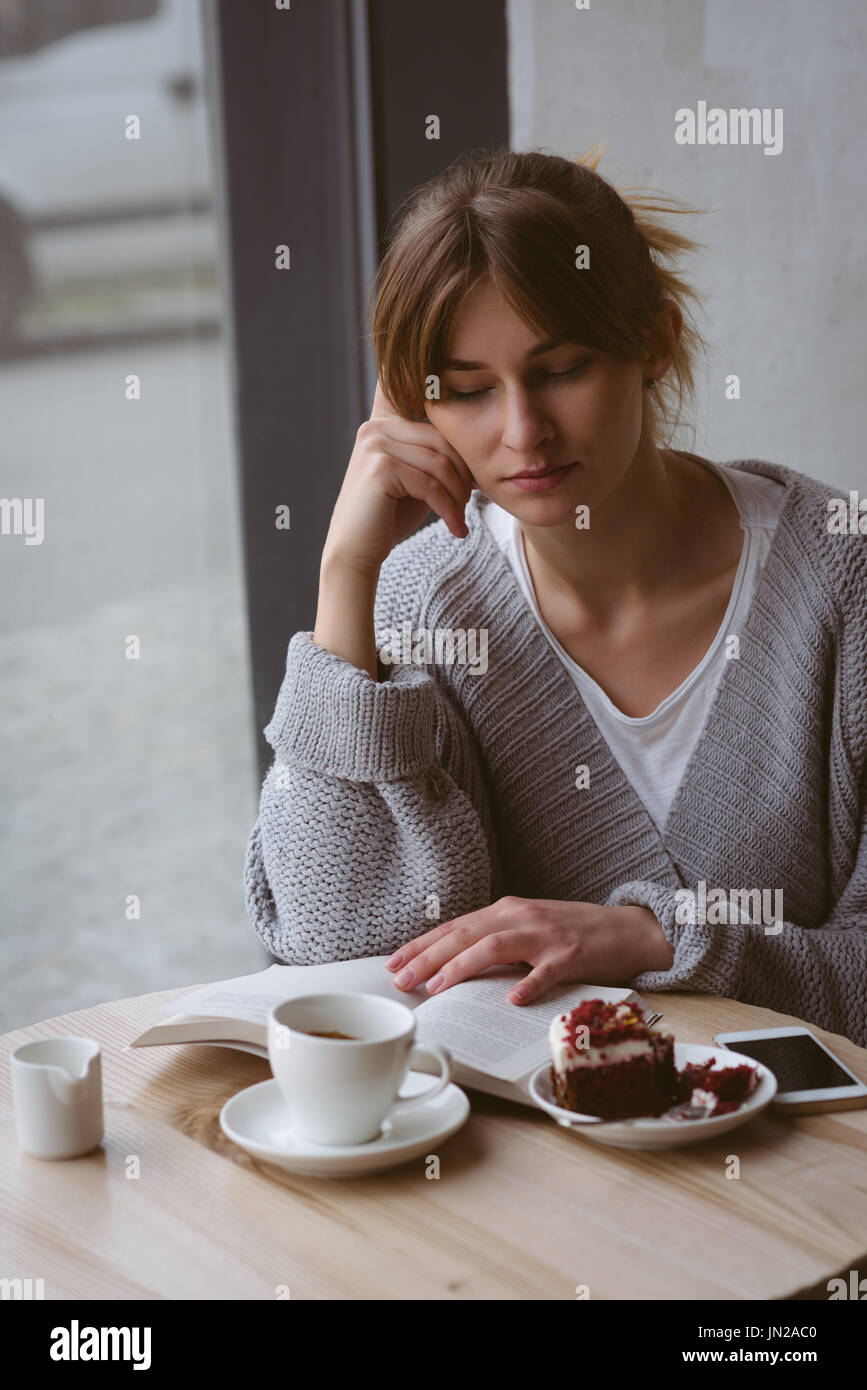 Schöne Frau Lesebuch im café Stockfoto
