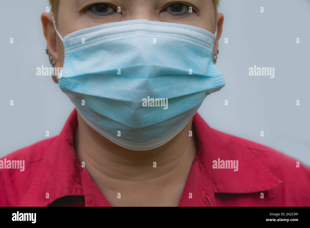 Frau leiden krank und tragen Mundschutz. Frau in Schutzmaske schlecht fühlen. Stockfoto