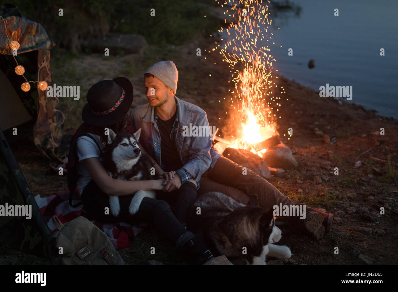 Paar an jedem anderen Suchen mit Hunden zelt Natur Stockfoto