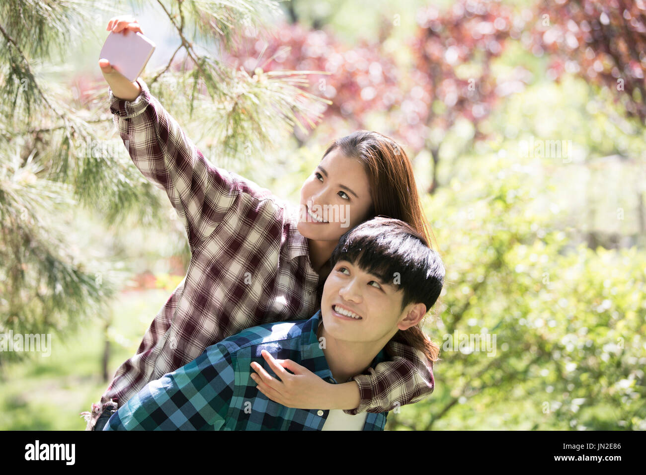 Junges Paar unter Selbstbildnis mit Handy Stockfoto