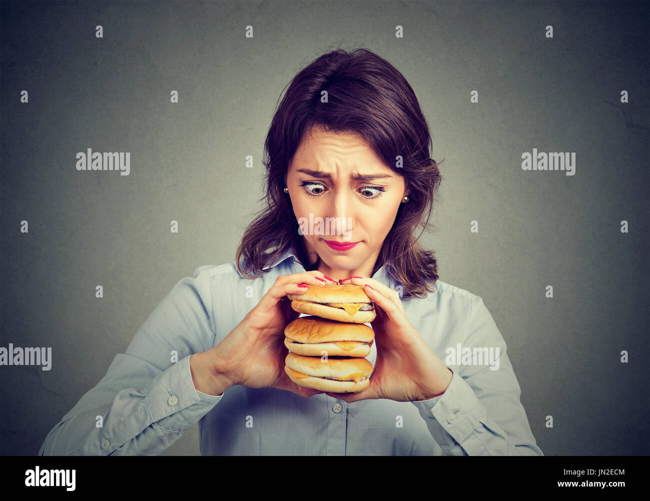 Frau, die Lust auf eines leckeren Dreifach Burger Essen Stockfoto