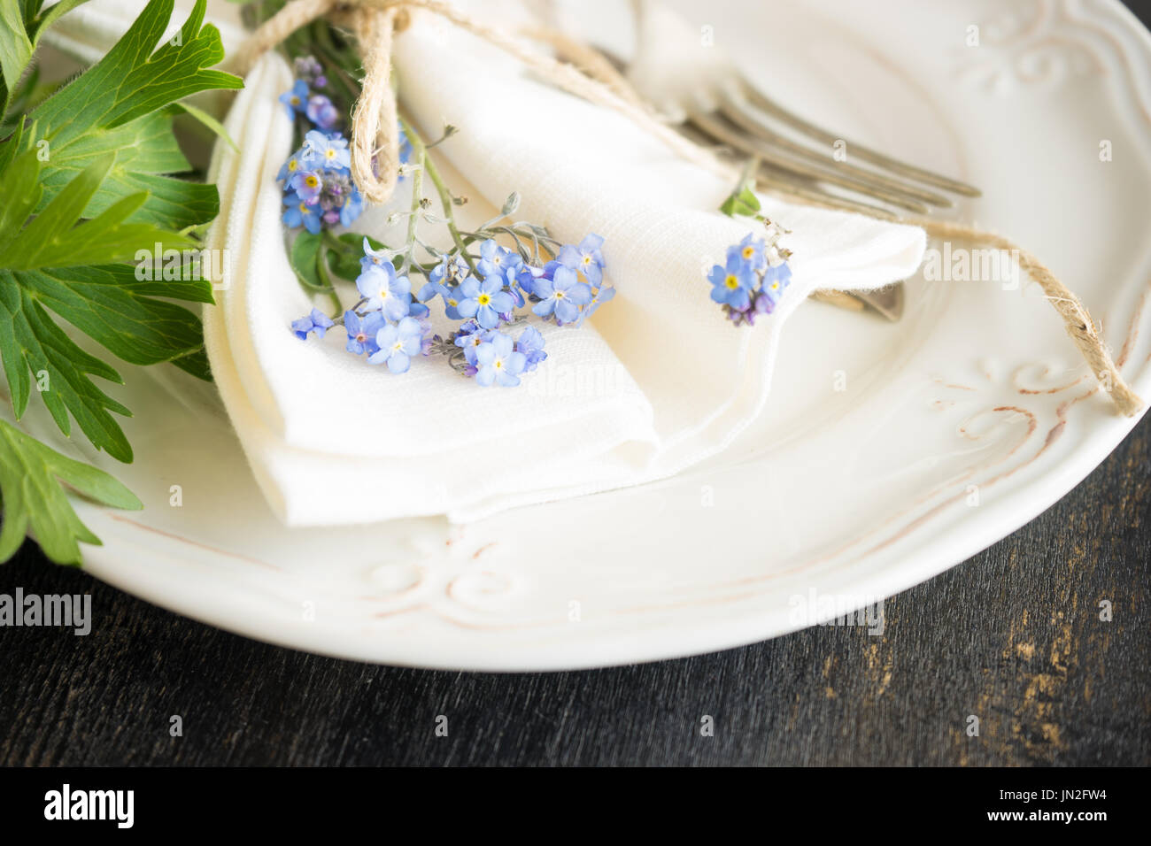 Sommer rustikale Tischdekoration mit Blumen Vergissmeinnicht Stockfoto