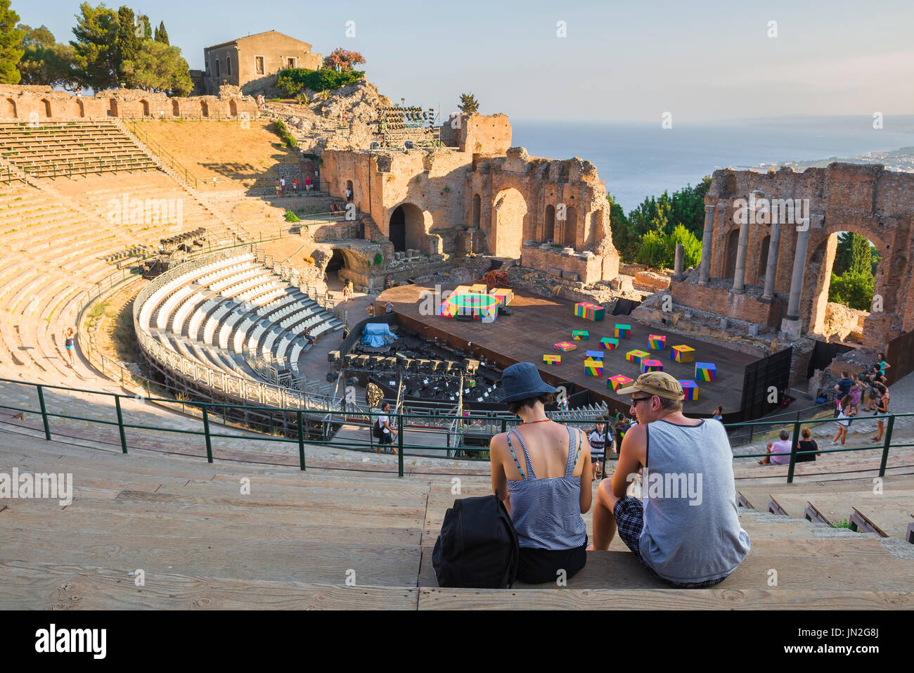 Italien bereist Sizilien, und an einem Sommerabend sehen Sie ein junges Touristenpaar im alten griechischen Theater in Taormina, Sizilien. Stockfoto