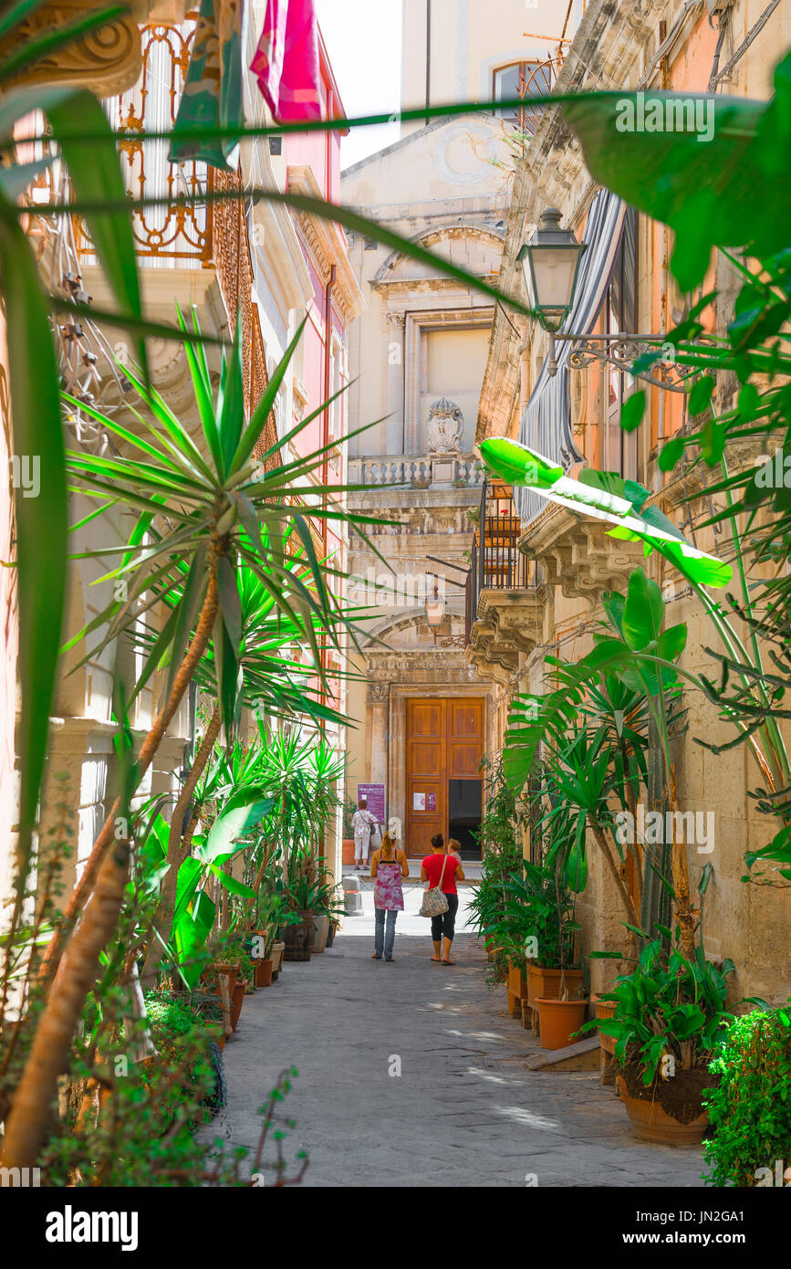 Syrakus Sizilien Straße, Blick im Sommer auf eine palmengesäumte Straße in der historischen Altstadt von Ortigia, Syrakus (Siracusa), Sizilien. Stockfoto