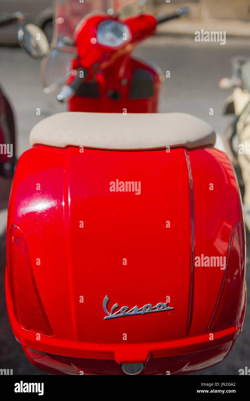 Rote Vespa-Roller, einen roten Motorroller geparkt in einer Straße in Syrakus auf Sizilien. Stockfoto