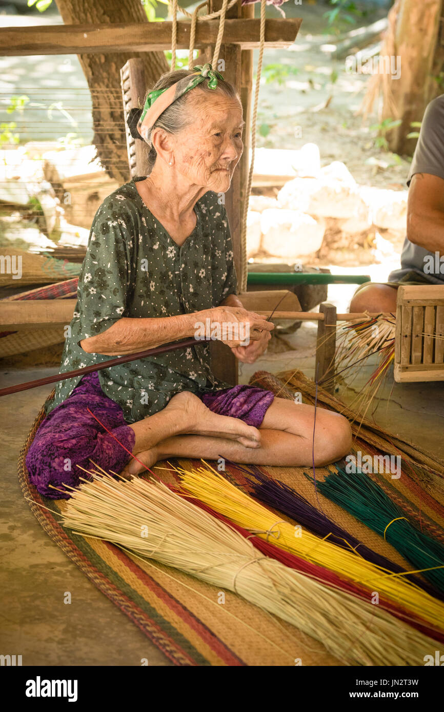 90-jährige Vietnamesin macht Schilfmatten, die mit traditionellen Methoden Stockfoto