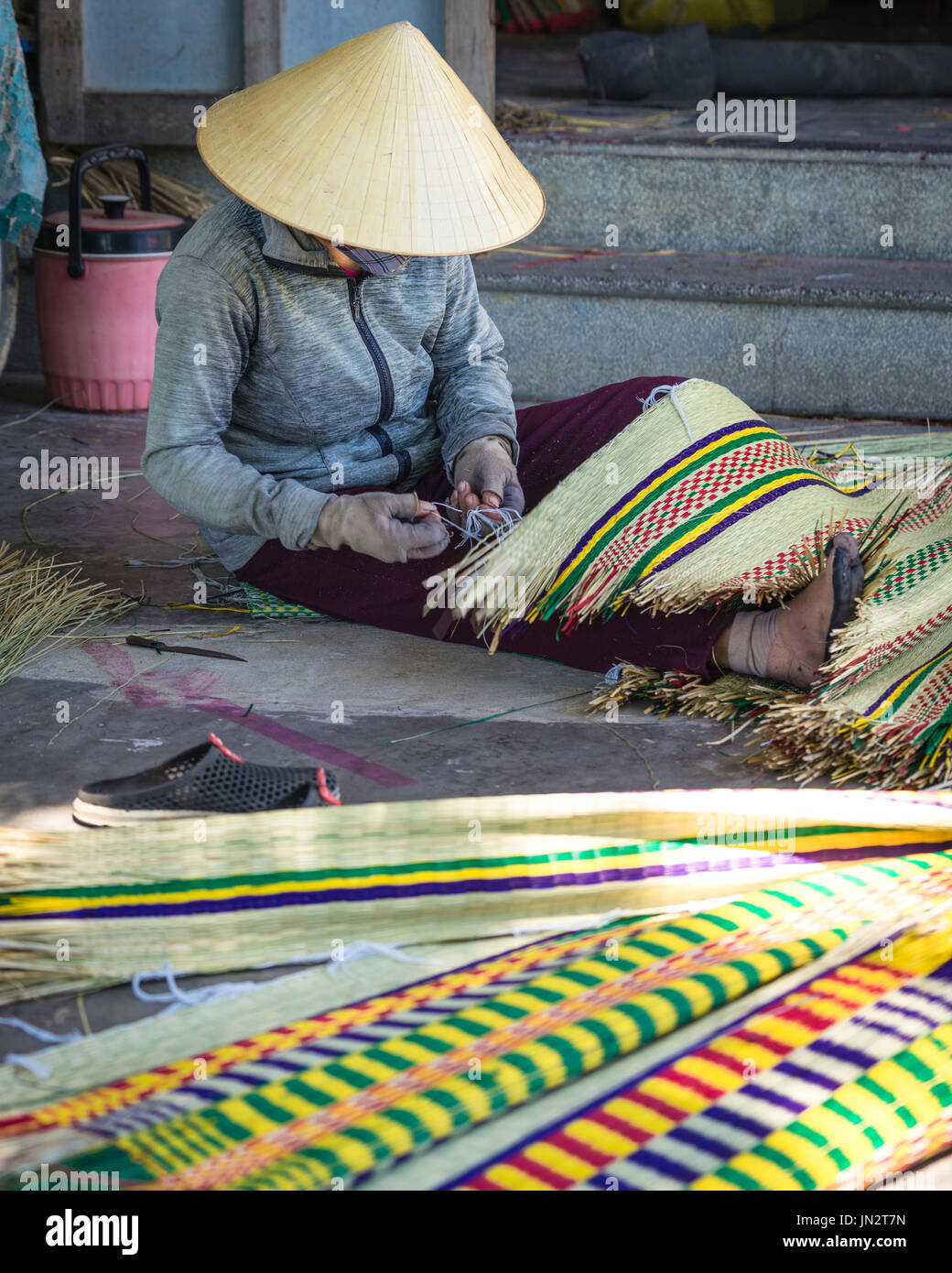Vietnamesin in konische Hut weben traditionelle Schilf-Matte Stockfoto
