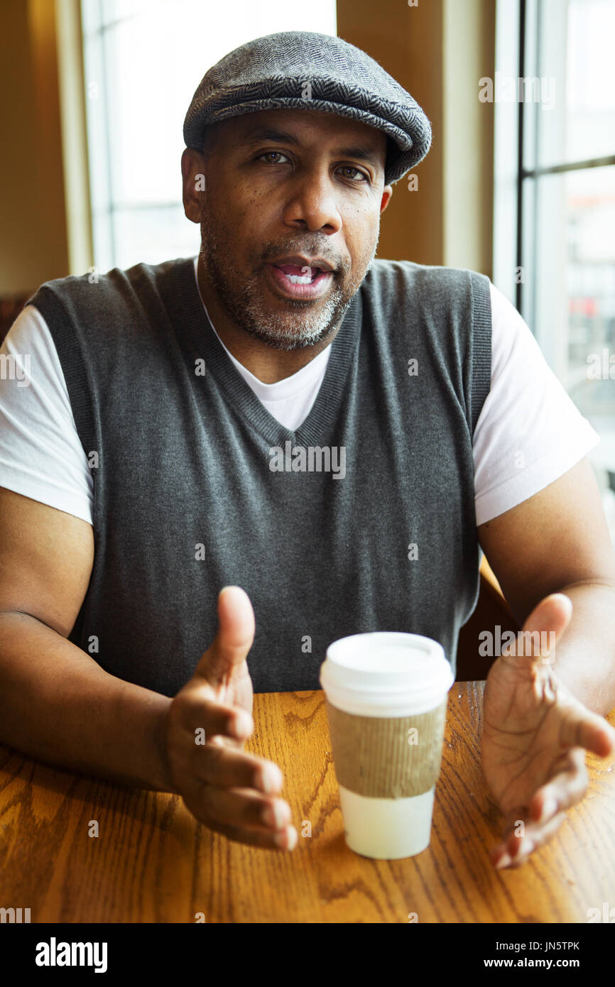 Reife afroamerikanische Mann sitzt in einem Café. Stockfoto