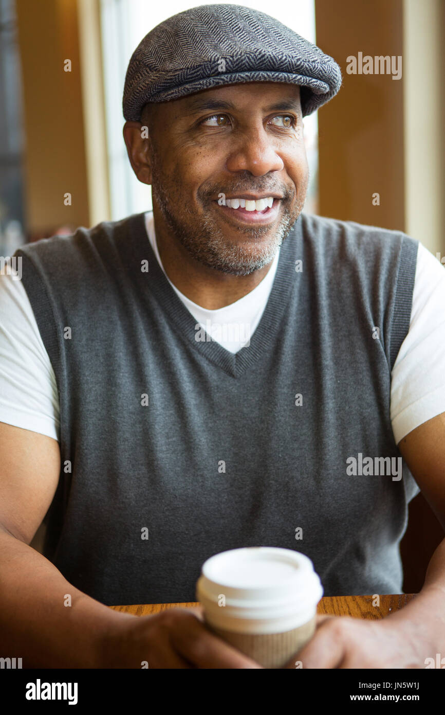 Reife afroamerikanische Mann sitzt in einem Café. Stockfoto