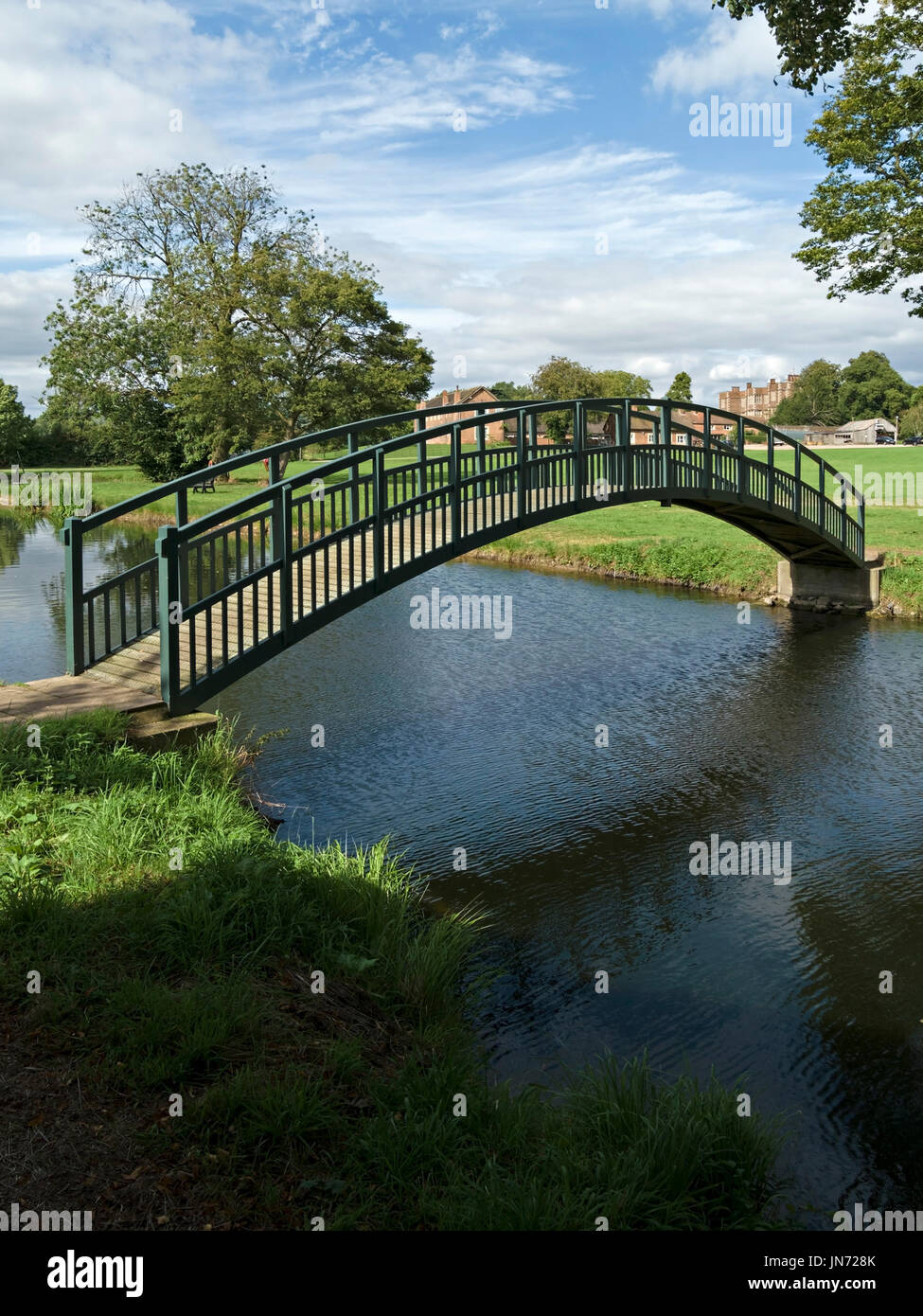 Intelligente neue, einzelne Bogen Fussgänger Holzsteg über den Teich auf dem Gelände des Doddington Hall Estate, Lincolnshire, England, UK Stockfoto