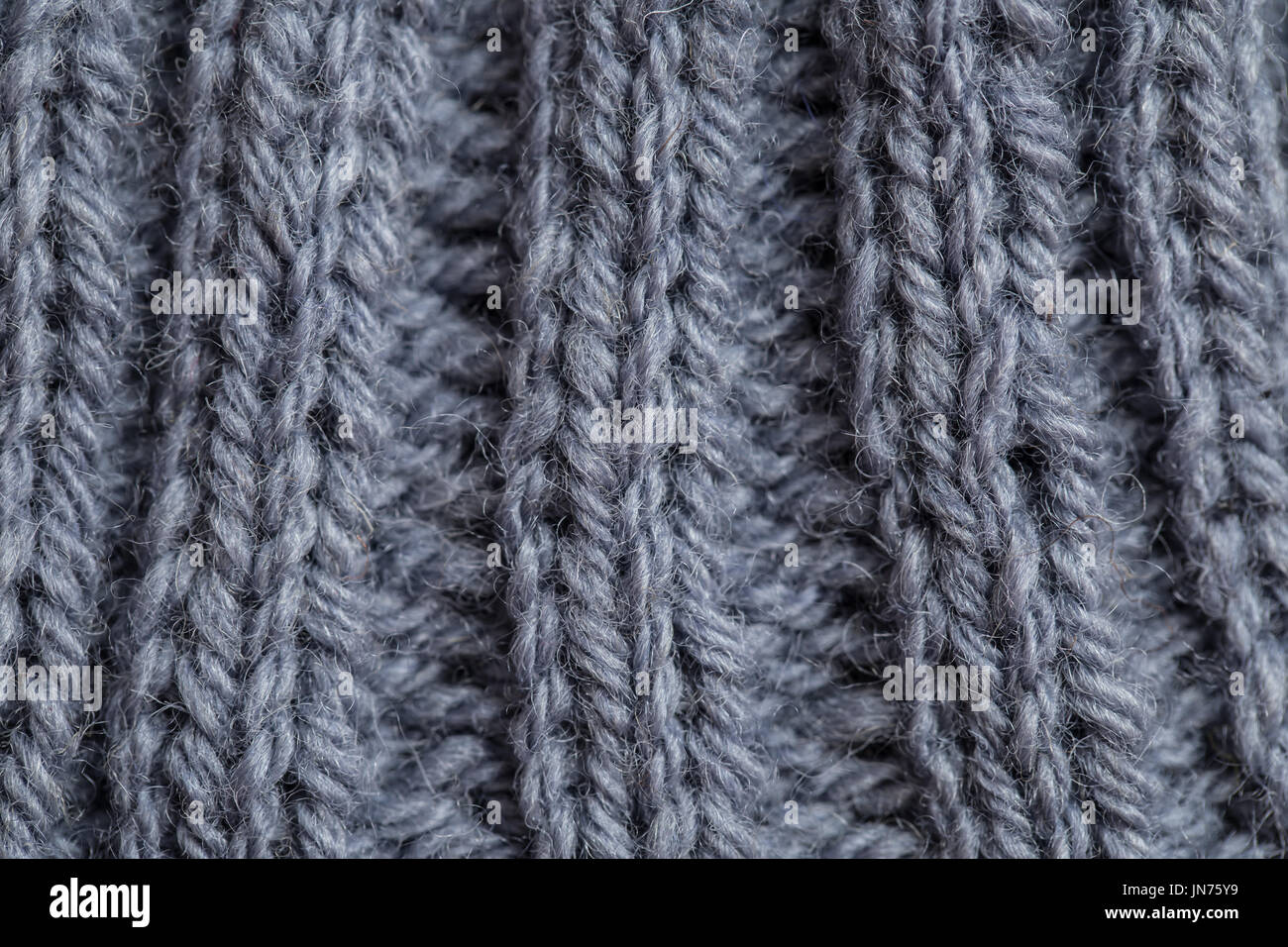Eine schöne Nahaufnahme von einer Hand gestrickte warme und weiche Wolle Muster. Weiche Socken oder Schal aus Naturwolle. Bunte Muster. Stockfoto