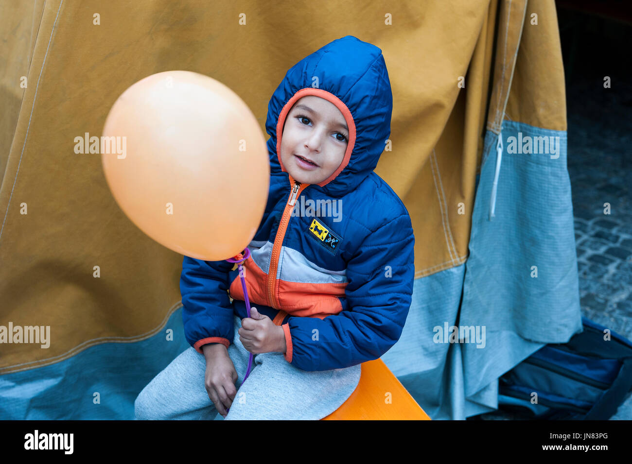 München, Deutschland - 7. September 2015: Flüchtlingskind aus Syrien mit einem Ballon an der Registrierung Camp. Der Junge kam nach der Flucht aus dem Bürgerkrieg. Stockfoto