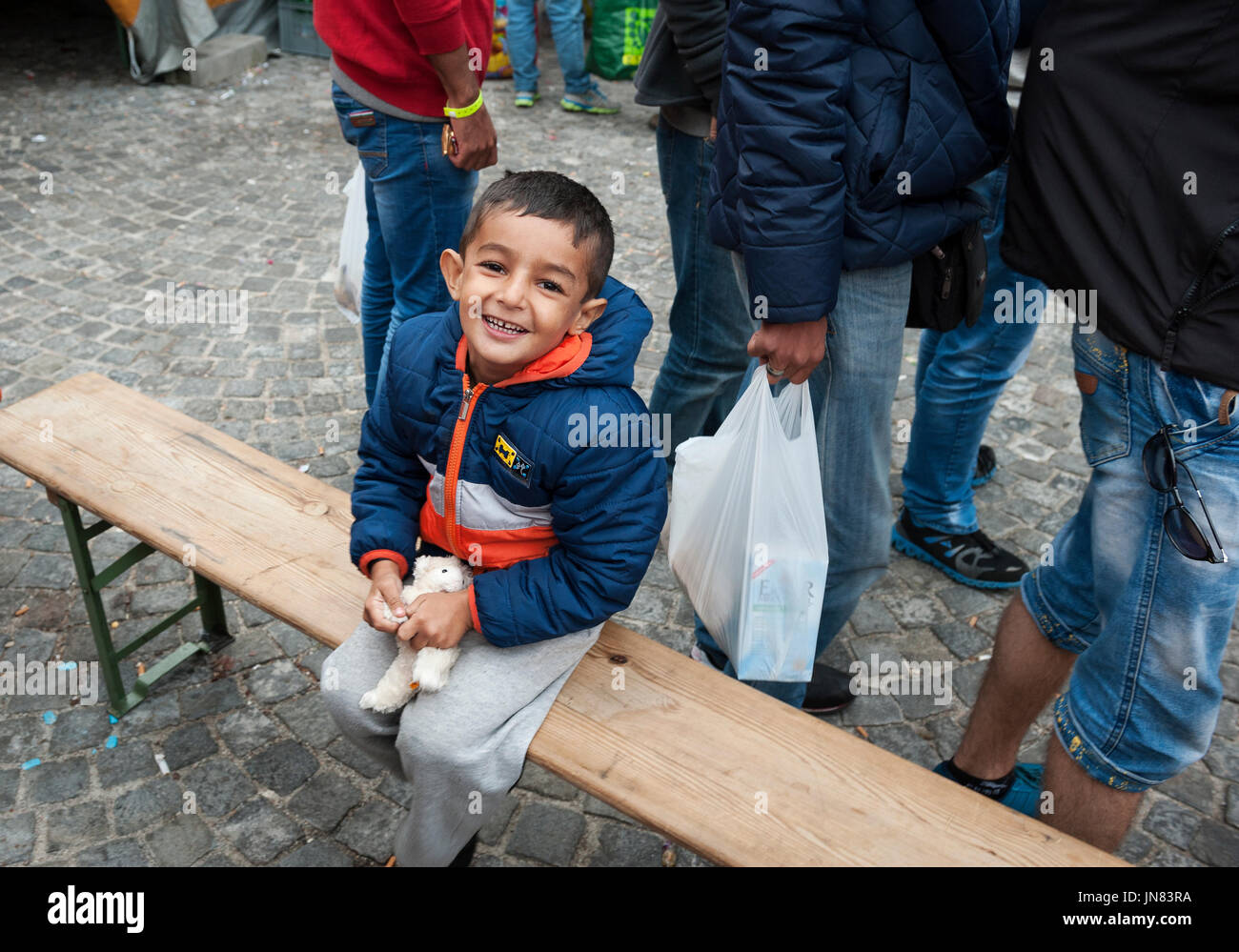 München, Deutschland - 7. September 2015: Flüchtlingskind aus Syrien am Münchner Hauptbahnhof, Deutschland. Der Junge lächelt nach Ankunft in Deutschland. Stockfoto