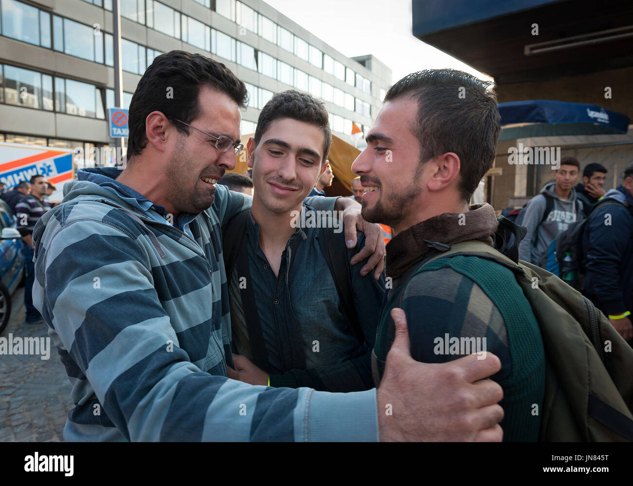 München, Deutschland - 8. September 2015: ein Onkel und Neffe aus Syrien sind beide in Tränen aus, als am Münchner Hauptbahnhof wieder vereint. Stockfoto