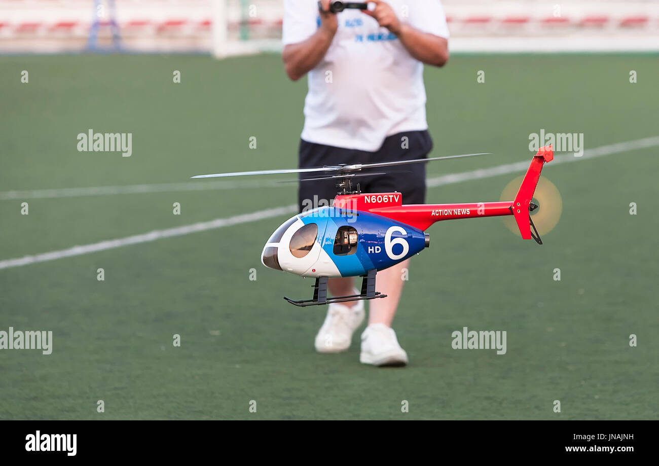 Mann Pilotierung winzige ferngesteuerte Hubschrauber in dem Fußballplatz, Spanien Stockfoto