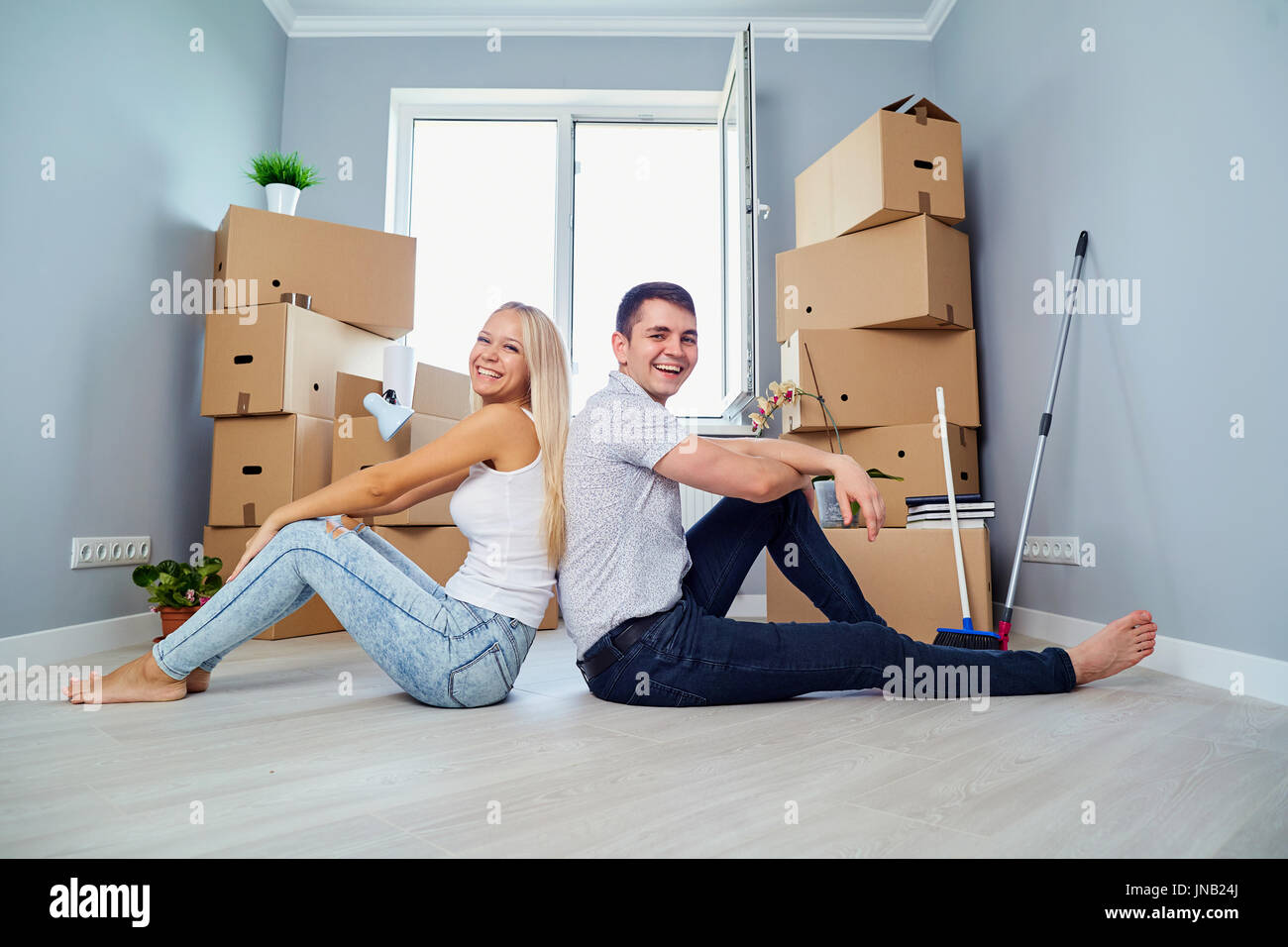 Junges Paar auf dem Boden in einem neuen Haus. Stockfoto